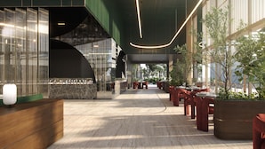 Un moderno vestíbulo de hotel con mostrador de recepción, zona de estar y grandes ventanales.