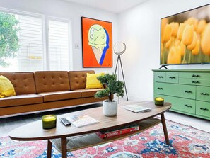 A living room with a sofa, coffee table, television, and a green cabinet. - LUX 6BR/3BA Villa, 10m 2 Strip, Pool+Spa+7 carpark (Henderson)