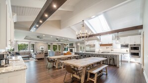 A spacious kitchen with a large island, wooden flooring, and modern appliances.
