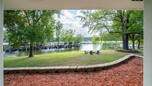 A view of a park with a lake, benches, and a dock area.