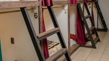 Bunk beds with numbers on the wall, a tiled floor, and a blanket on one bed.