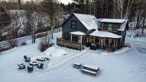 A two-story house with a covered porch and a snow-covered yard. - The Homestead - Walk to village, bring the pup! (Johnson)