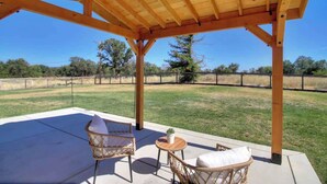 An outdoor patio with wooden pergola, wicker chairs, and a small round table. - Country Property, W&D, Open Concept, Pet Friendly (Loomis)