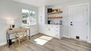 A modern kitchen with white cabinets, a wooden desk, and a window overlooking a scenic view. - Country Property, W&D, Open Concept, Pet Friendly (Loomis)