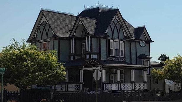 A Victorian-style house with a prominent front porch, multiple windows, and a decorative roof. - The Bissing House (Hays)