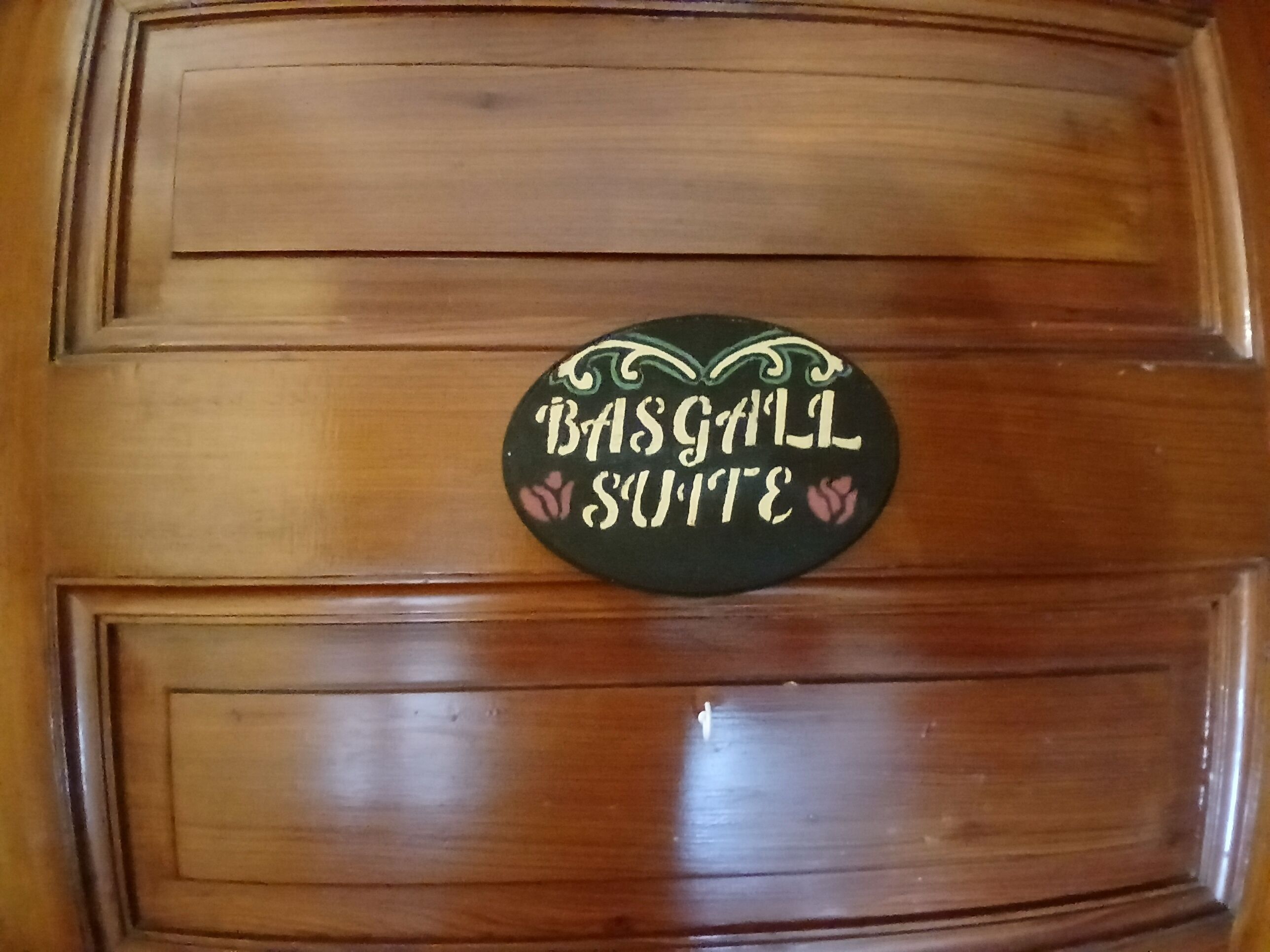A wooden door with a sign that reads "Basgall Suite".
