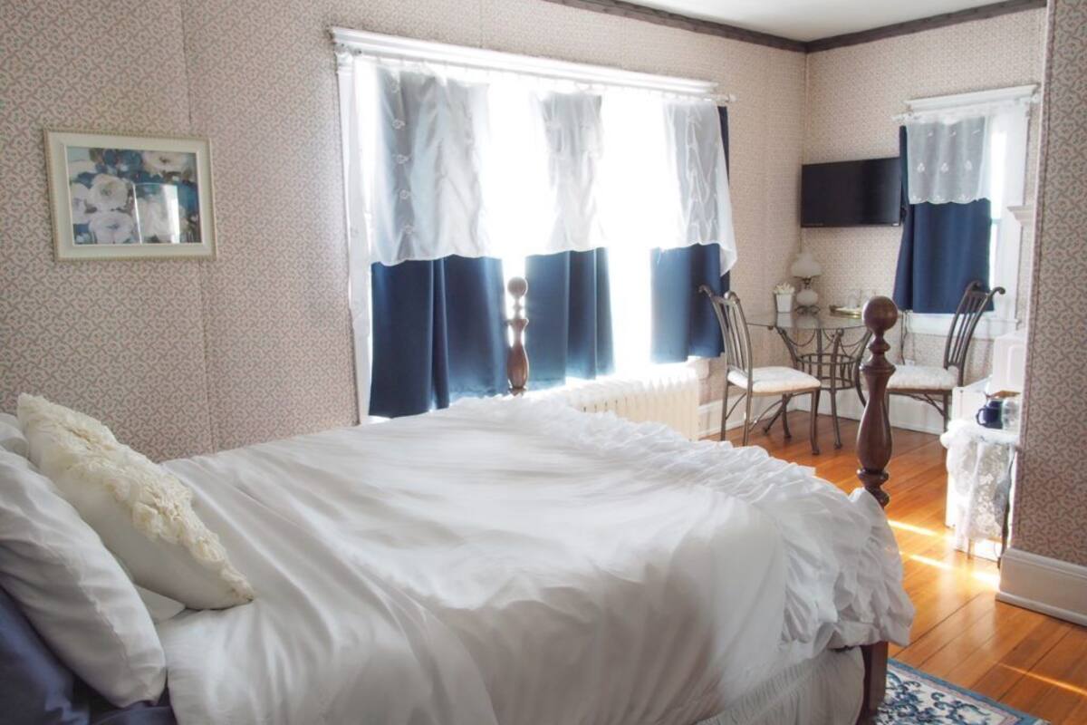 A bedroom with a large bed, a desk, and a chair.