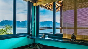 A room with large windows overlooking a mountainous landscape and a body of water. - Casa Tiffany - Ilhabela (Ilhabela)