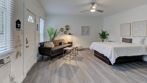 A bedroom with a bed, a sofa, a small table, a ceiling fan, and a window with blinds. - Stunning Memphis` Neighborhood-Guest House Retreat (Memphis)