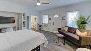 A modern hotel room with a bed, a sofa, a desk, and a ceiling fan. - Stunning Memphis` Neighborhood-Guest House Retreat (Memphis)