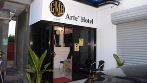The exterior of Arte' Hotel with a black and white facade, a visible entrance, and a sign indicating a sanitization station nearby. - GMB ARTE' HOTEL R#2 FAMILY SUITE ROOM (Sogod, Southern Leyte)