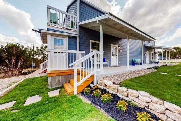 Stunning two-story home with a spacious balcony and covered front porch.
