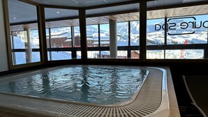 Un bain à remous avec vue sur les montagnes enneigées, grâce à de grandes fenêtres.