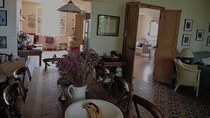 Un coin repas avec une table en bois, des chaises, un vase avec des fleurs et une assiette contenant une banane.