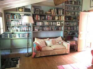 A cozy living room with a sofa, a lamp, and a bookshelf filled with books.