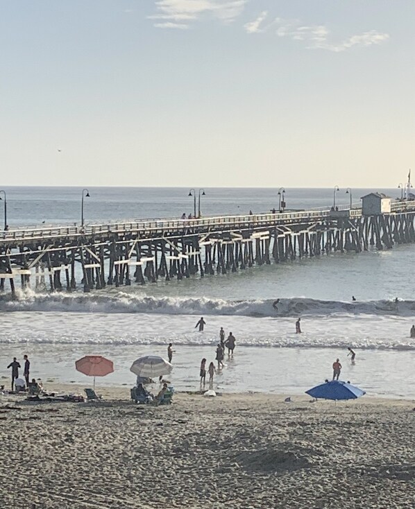 A pier extending into the sea with people walking along it.
