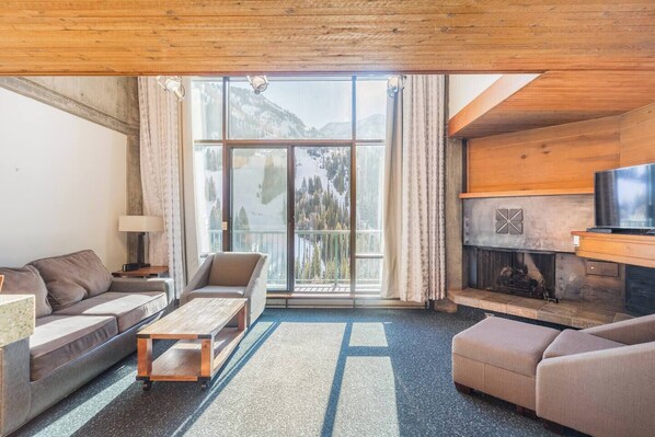 Ein gemütliches Wohnzimmer mit Sofa, Sessel und Kamin.