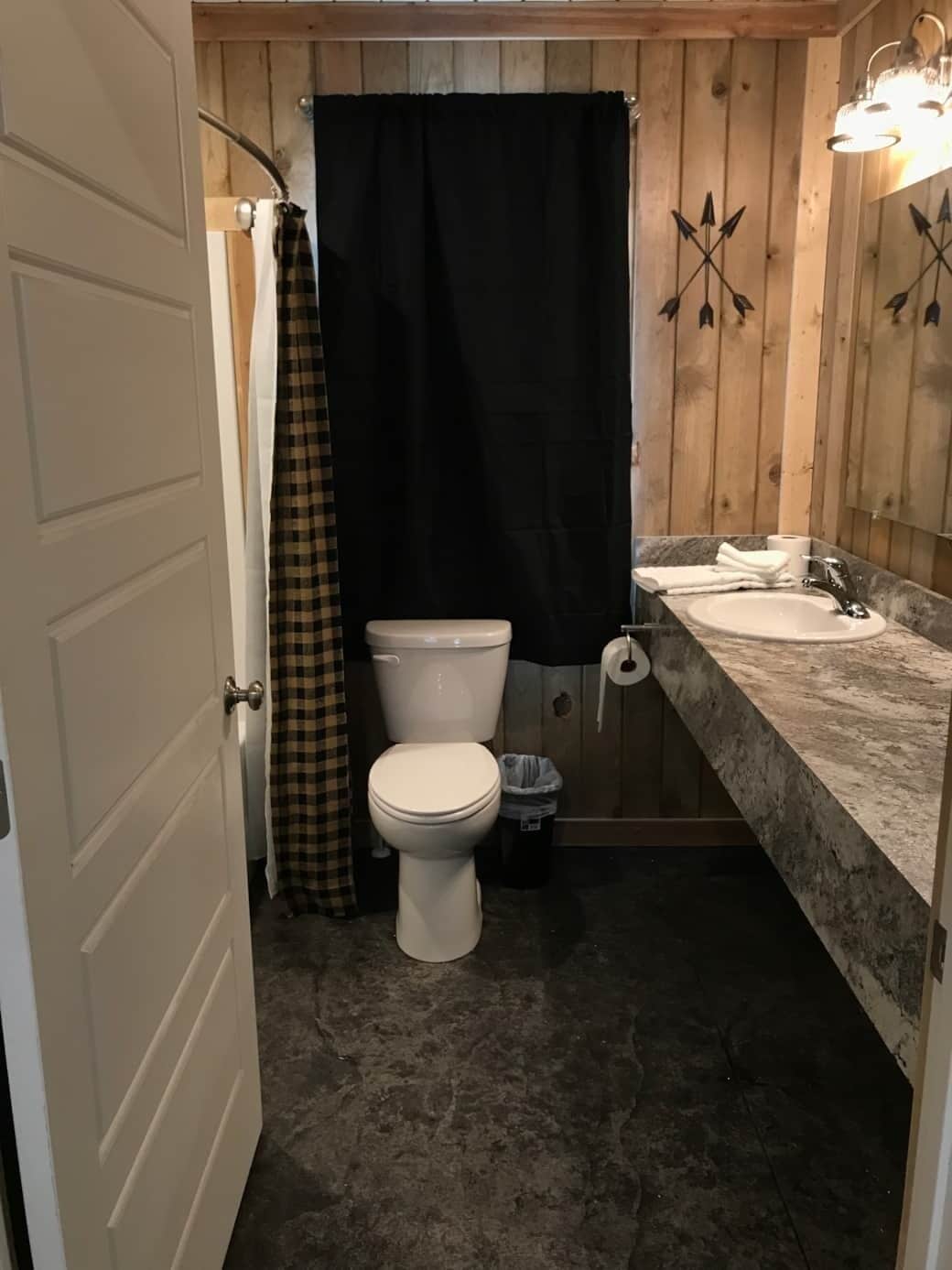 A small bathroom with a toilet, a sink, and a shower curtain.