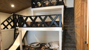 A bunk bed with a ladder, a small desk, and a slide.