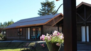 A wooden building with a sloped roof and a large hanging flower pot.