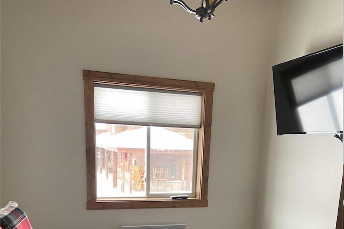 Une chambre à coucher avec un lit, une fenêtre et un ventilateur de plafond.