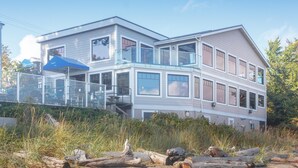 A two-story building with a balcony, large windows, and a glass railing. - Elegant Condo with Private BBQ and Ocean Views (Saanich North)