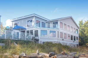 A two-story building with a balcony, large windows, and a glass railing. - Elegant Condo with Private BBQ and Ocean Views (Saanich North)
