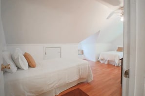 Une chambre à coucher avec un lit, une petite table et une chaise.