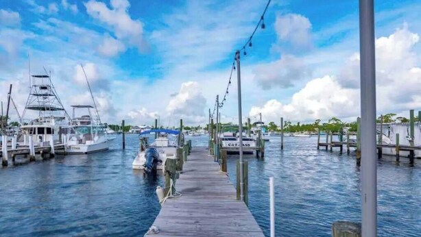 A marina with docked boats and a wooden pier extending into the water. - Manatee Pocket! 1 Bedroom, 1 Bath Unit To Yourself (Stuart)