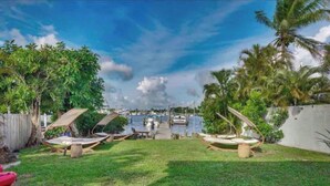 A grassy area with hammocks and a view of a marina with boats. - Manatee Pocket! 1 Bedroom, 1 Bath Unit To Yourself (Stuart)