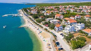 Eine Vogelperspektive einer Küstenstadt mit Strand, Häusern und Booten.