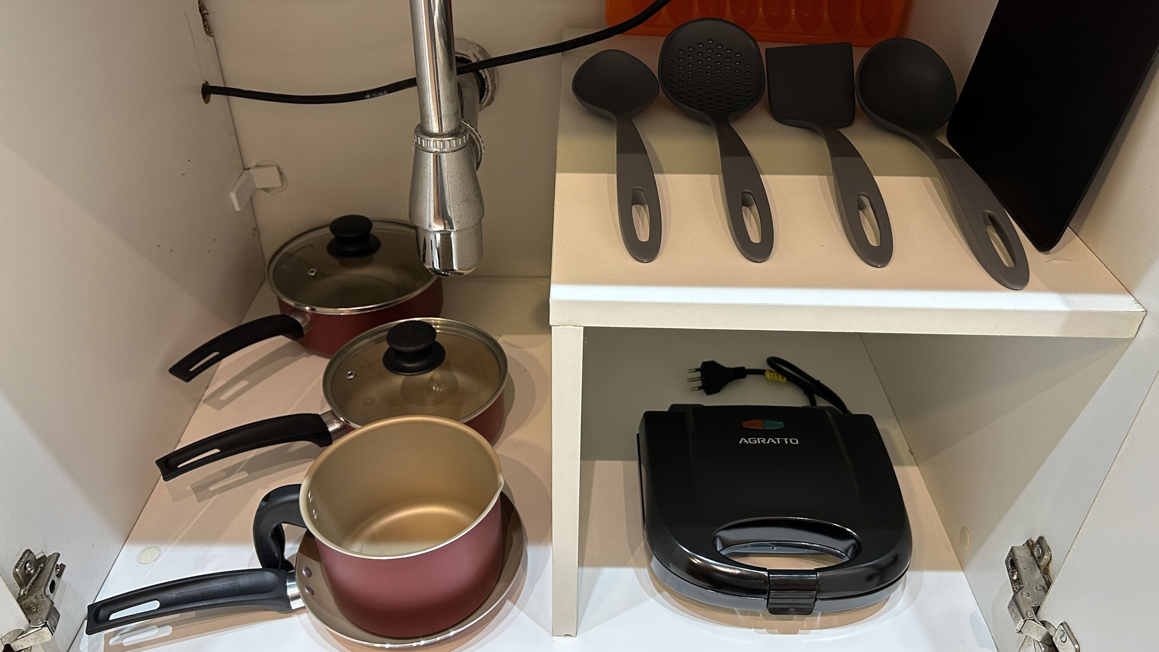 Un coin cuisine équipé de casseroles, de poêles, d’une bouilloire et d’une machine à café.