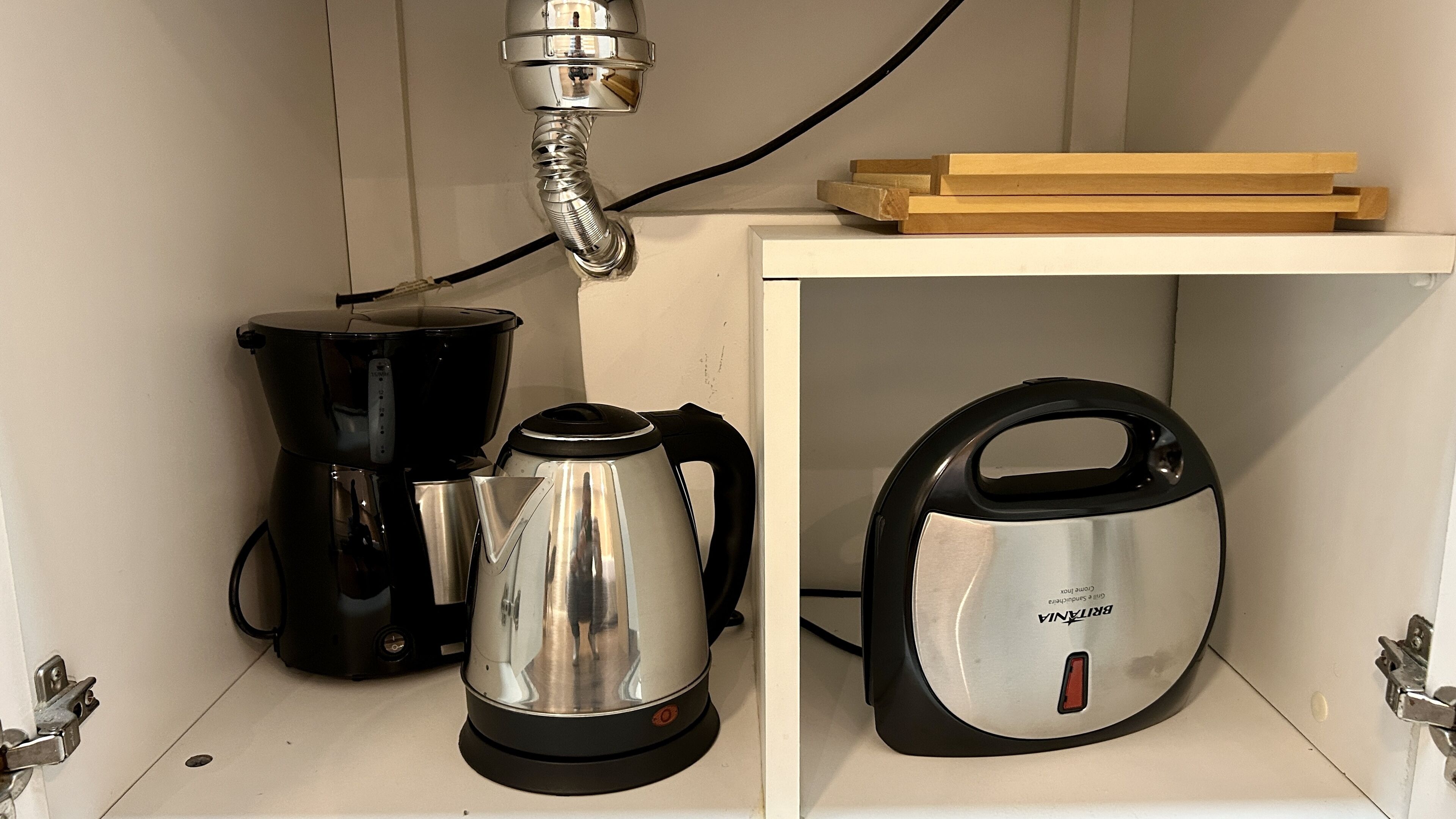 Une cuisine équipée d’une machine à café, d’une bouilloire et d’un filtre à eau Brita.