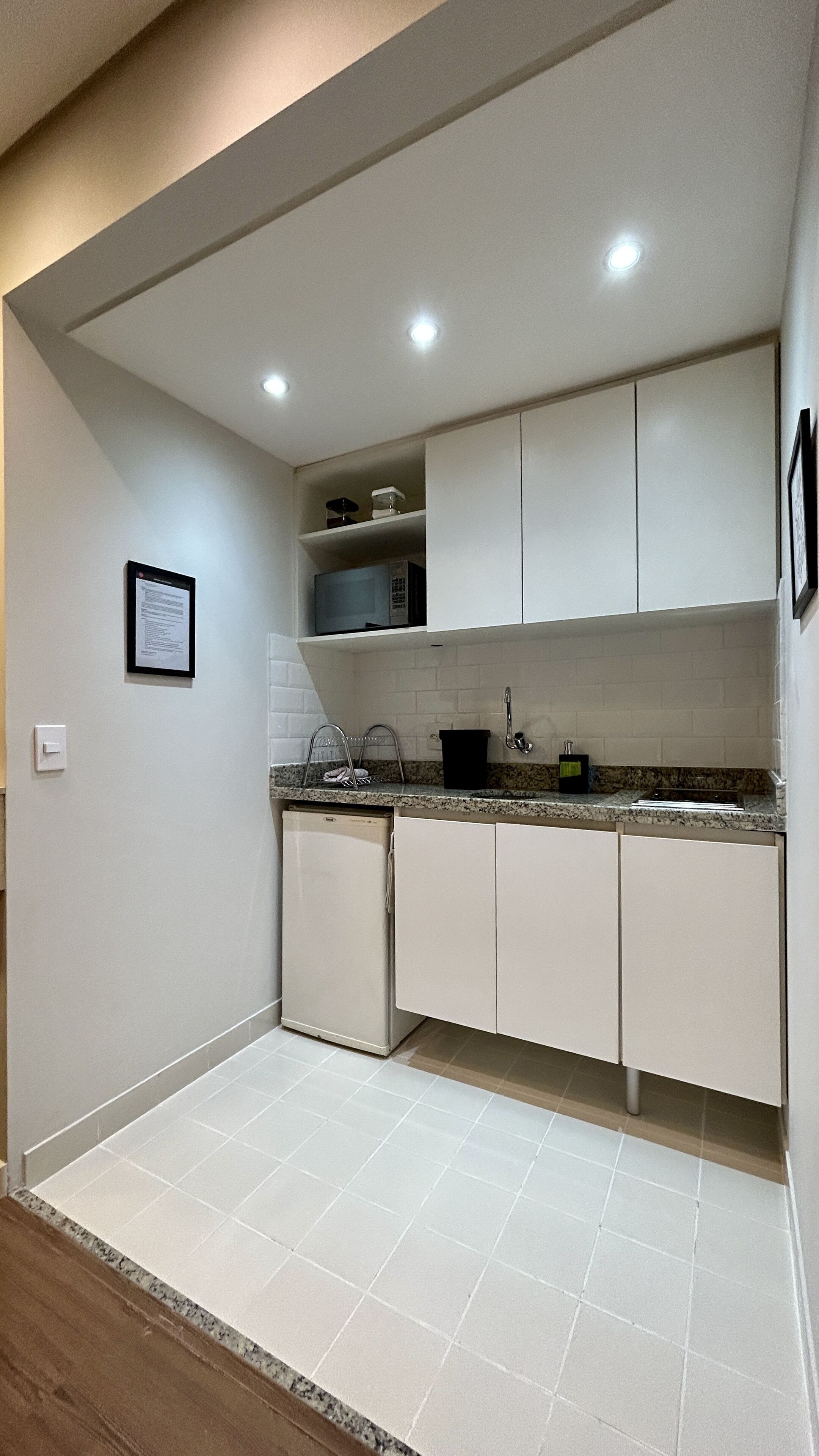 A modern kitchen with white cabinets, a granite countertop, and a tiled backsplash.