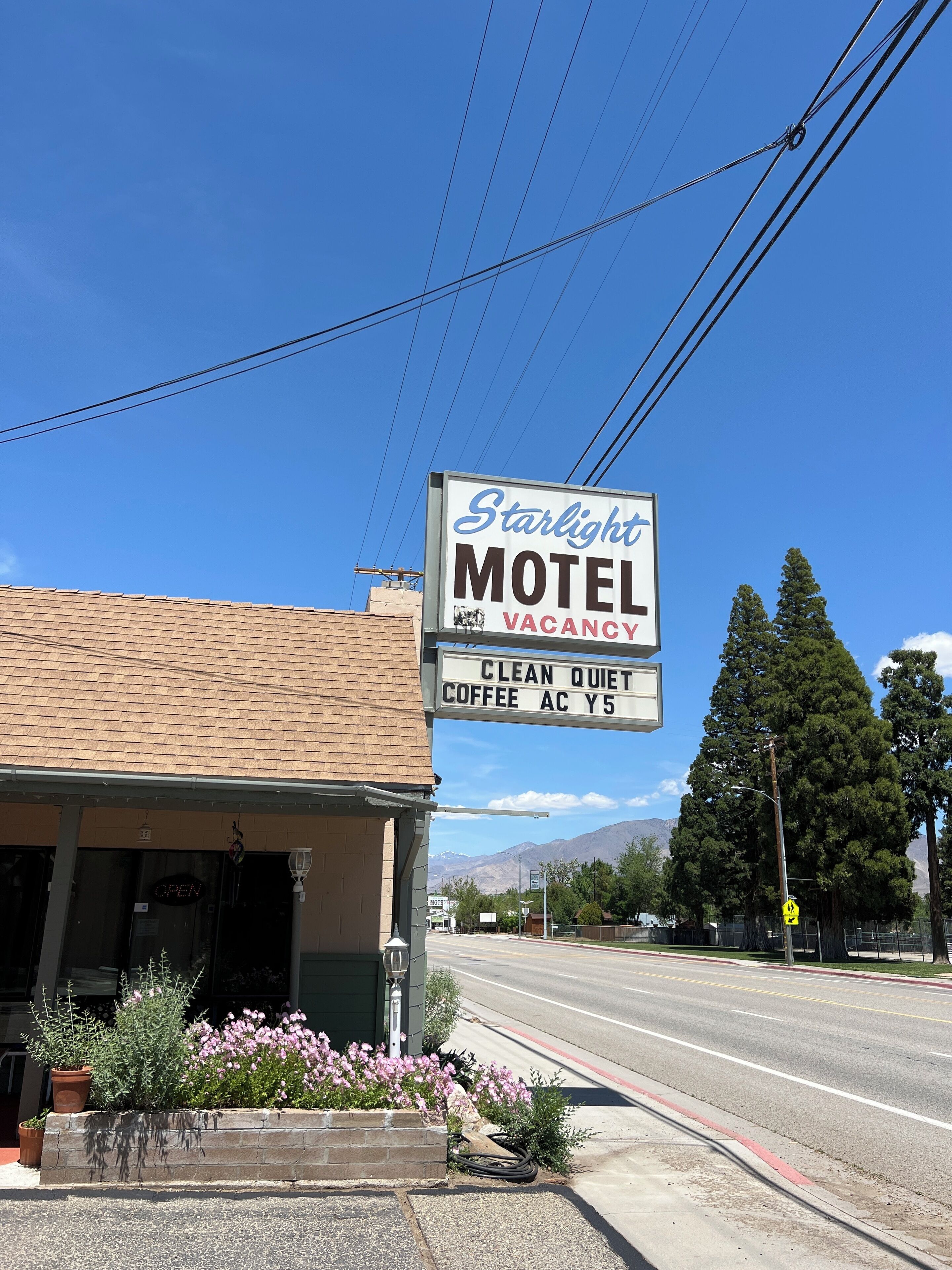 A motel sign with a 'VACANCY' notice and a 'CLEAN QUIET' description.