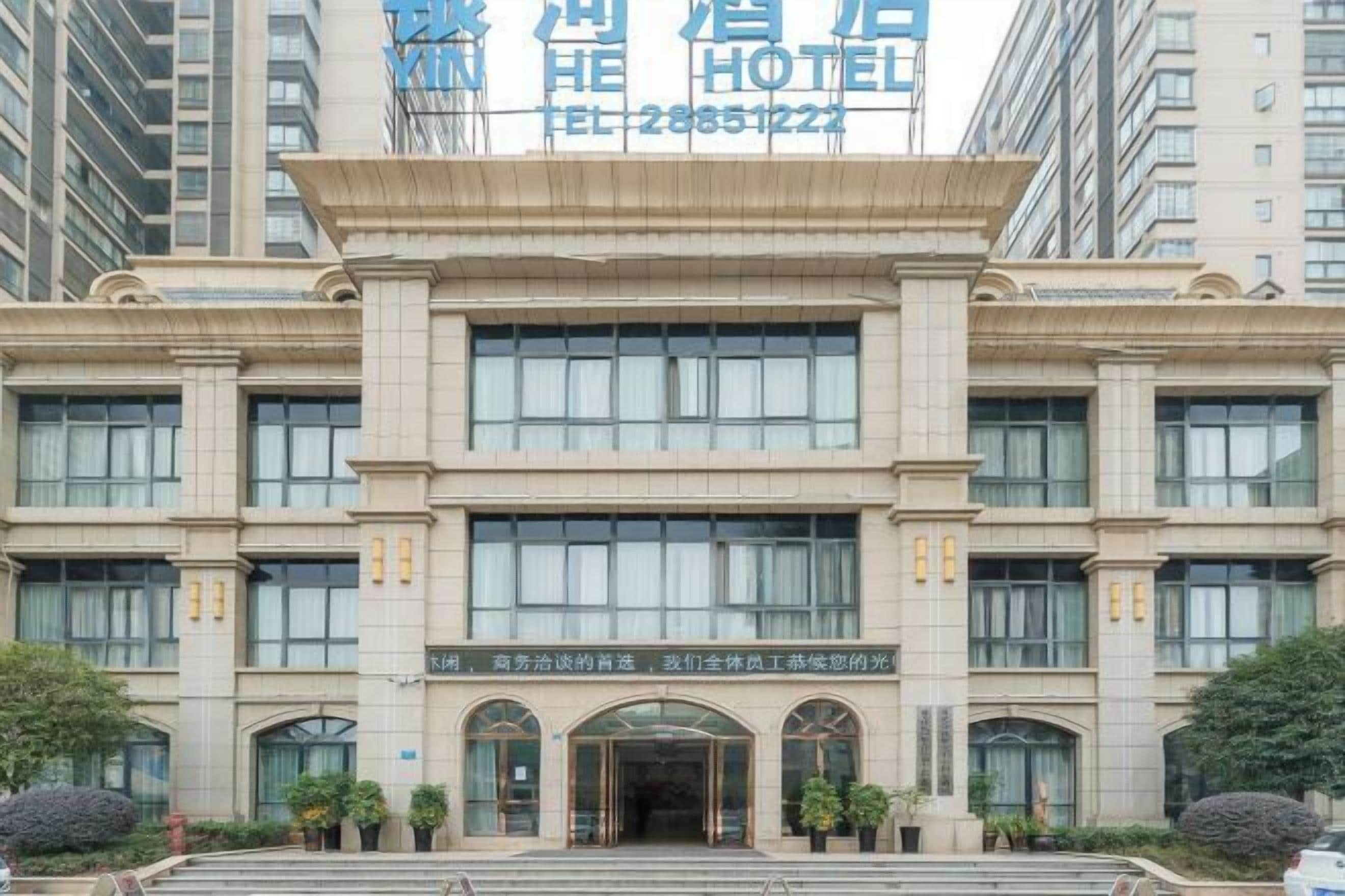 A hotel building with a classical architectural style, featuring multiple windows and a central entrance.