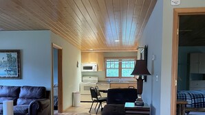 A cozy cabin interior with a living room, dining area, and kitchen. - Beautiful 2 bedroom house  with a boat dock on the Chippewa Flowage  (Hayward)