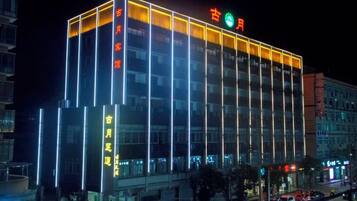 A multi-story building with illuminated signage and a modern architectural design.