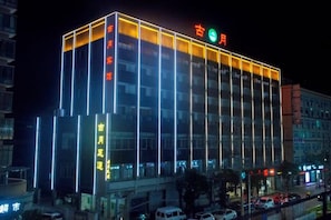 A multi-story building with illuminated signage and a modern architectural design. - Guyue Hotel (Shengzhou Wuyue Plaza Branch) (Shengzhou)