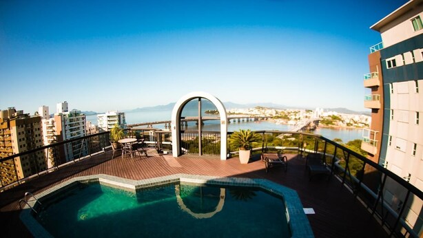 A rooftop pool with a clear view of the city and a bridge in the background. - Rooftop Pool with Sea and Bridge Views #CA22 (Florianópolis)
