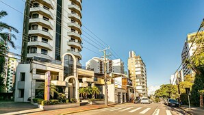 A multi-story building with balconies and a pedestrian walkway. - Rooftop Pool with Sea and Bridge Views #CA22 (Florianópolis)