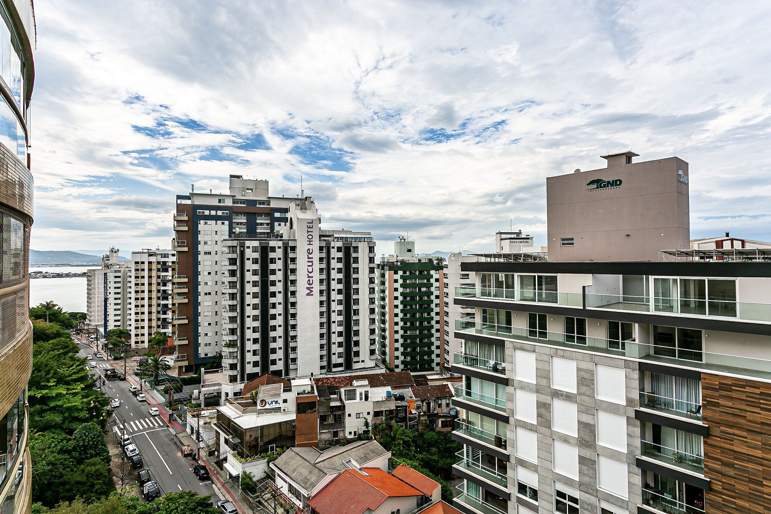 A high-rise hotel with multiple floors, balconies, and a view of the cityscape.