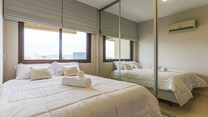 A hotel room with a large bed, a mirror, and a window with blinds. - 350m Public Market | Walkable #CA10 (Florianópolis)