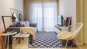 A modern living room with a sofa, a white chair, a coffee table, and a TV. - 350m Public Market | Walkable #CA10 (Florianópolis)