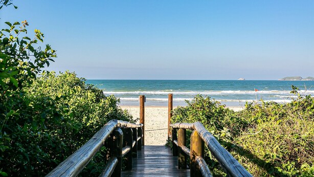 A wooden boardwalk leading to a beach with ocean views. - SEA VIEW | Balcony with Barbecue #IA09 (Florianópolis)