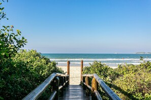 A wooden boardwalk leading to a beach with ocean views. - SEA VIEW | Balcony with Barbecue #IA09 (Florianópolis)