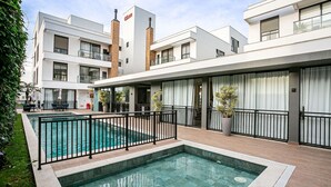 Un hôtel moderne doté d’une piscine, d’un espace extérieur aménagé et d’un jardin bien entretenu.