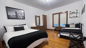 A bedroom with a bed, a desk, a chair, a dresser, and a large mirror. - Fun Haven! 2 Units in 1 house for private gatherings and games (South Haven)