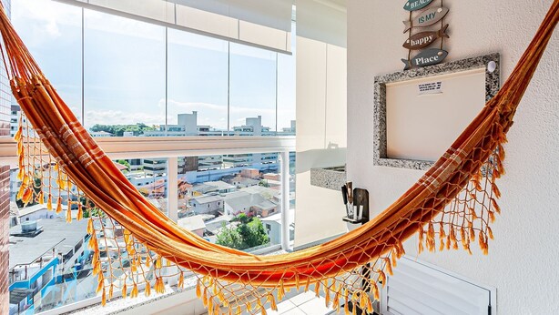 A room with a hammock, a city view, a wall decoration, and a framed picture.