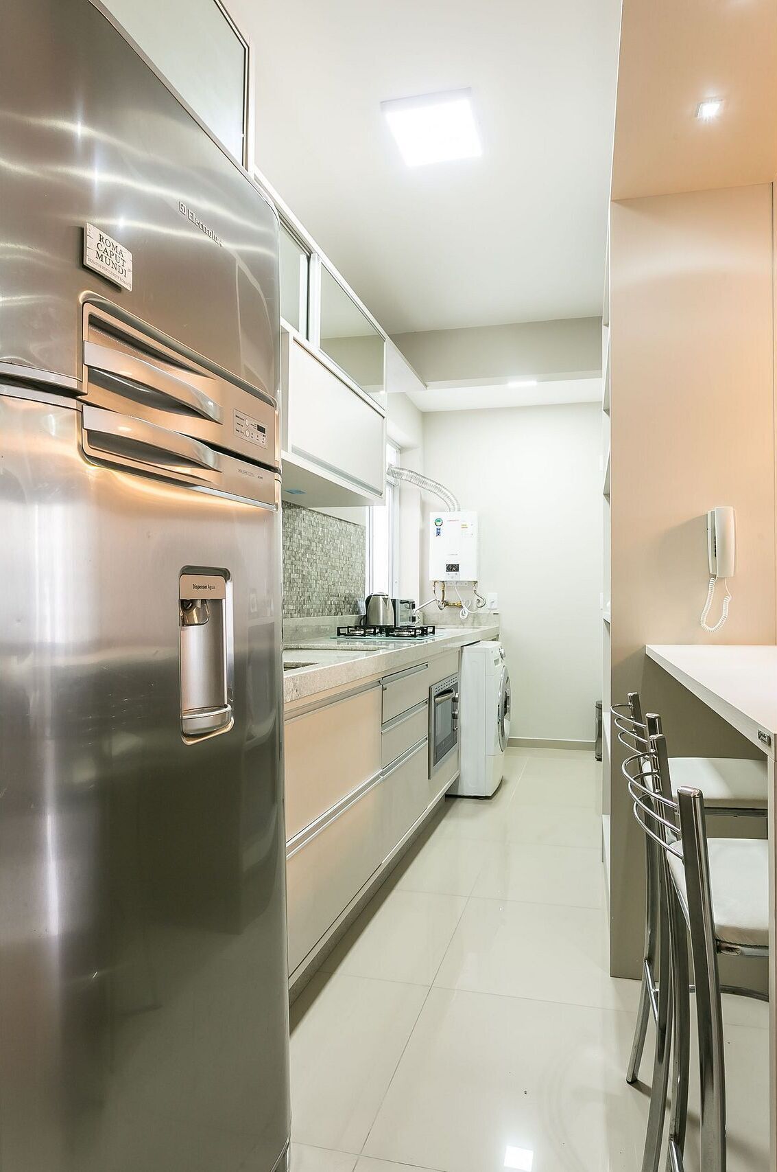 A modern kitchen with stainless steel appliances, a built-in oven, and a coffee maker.